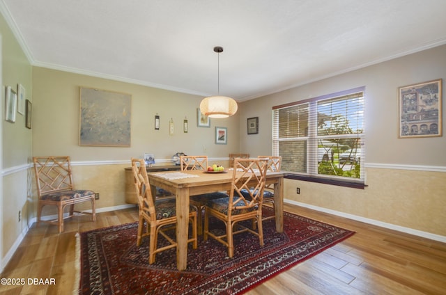 dining room with hardwood / wood-style floors and ornamental molding