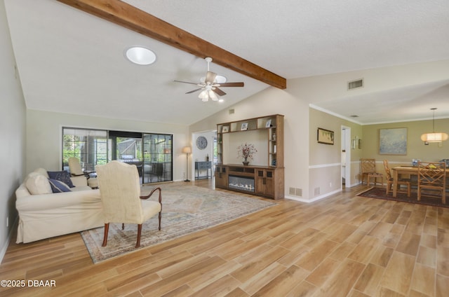 living room with a fireplace, ceiling fan, vaulted ceiling with beams, and wood-type flooring