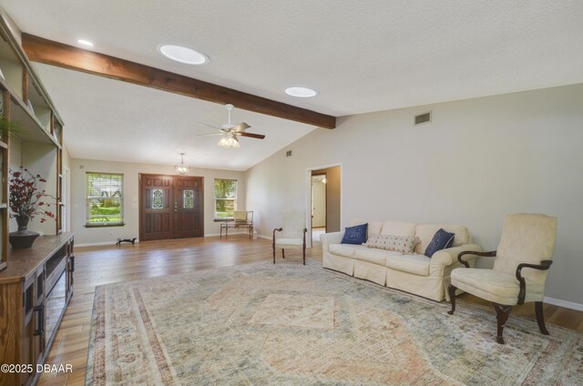 living room featuring ceiling fan, lofted ceiling, and light wood-type flooring