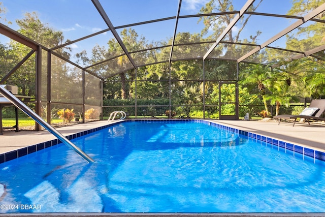 view of swimming pool featuring a patio area and a lanai