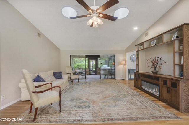 living room with ceiling fan, lofted ceiling with beams, and light hardwood / wood-style flooring