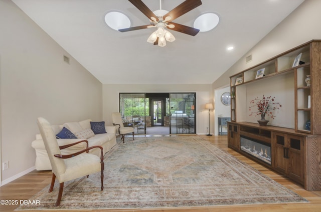 living room featuring light hardwood / wood-style floors, high vaulted ceiling, and ceiling fan