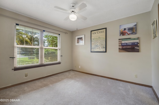 carpeted spare room featuring ceiling fan