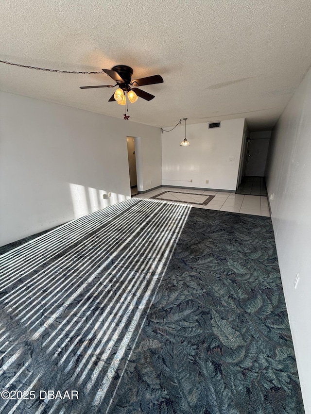 interior space featuring light tile patterned flooring, ceiling fan, and a textured ceiling