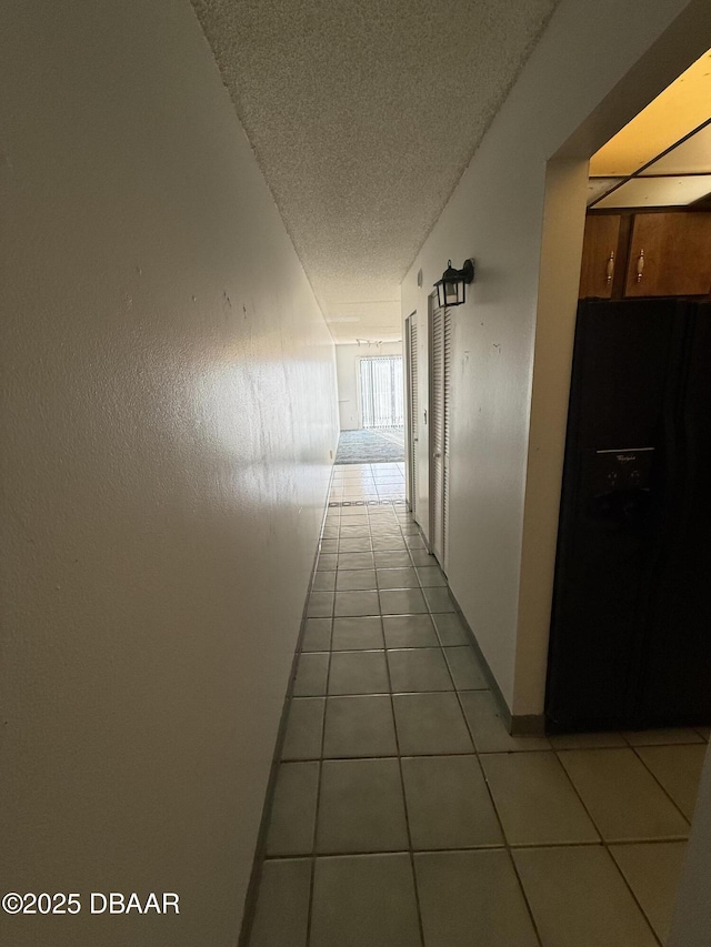 hall with tile patterned flooring and a textured ceiling