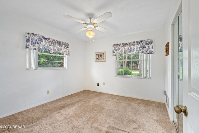 unfurnished room with ceiling fan and light colored carpet