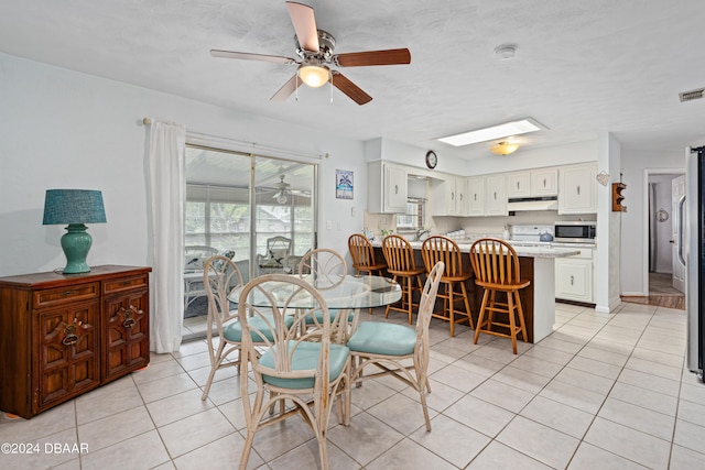 dining area with light tile patterned floors and ceiling fan