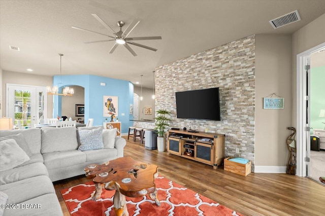 6341 Hanfield Dr, Port Orange, FL 32128 - living room featuring wood finished floors, ceiling fan with notable chandelier, baseboards, and visible vents