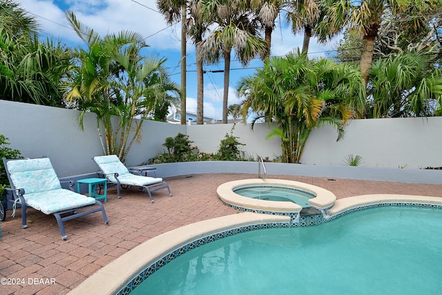 view of pool with a patio and an in ground hot tub