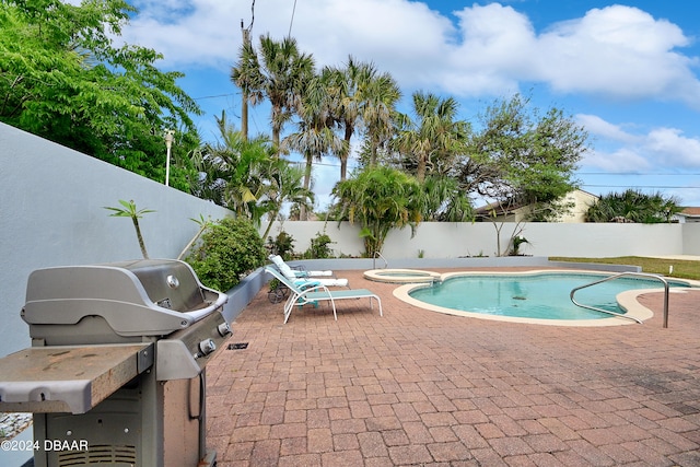 view of pool featuring a patio area and a grill