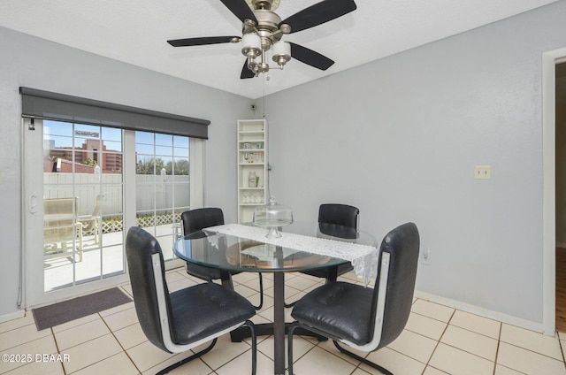 dining area with a ceiling fan, baseboards, and light tile patterned floors