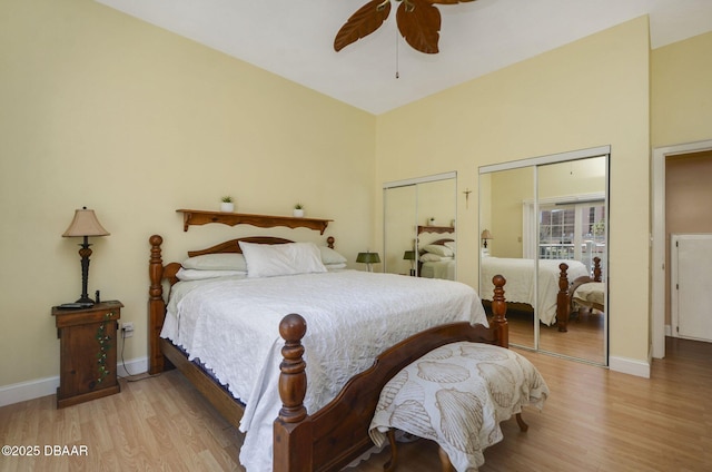 bedroom with a ceiling fan, baseboards, light wood finished floors, and two closets