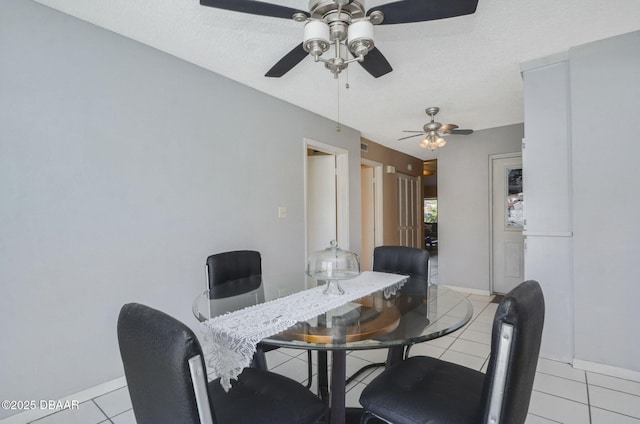 dining room with a textured ceiling, baseboards, and light tile patterned floors