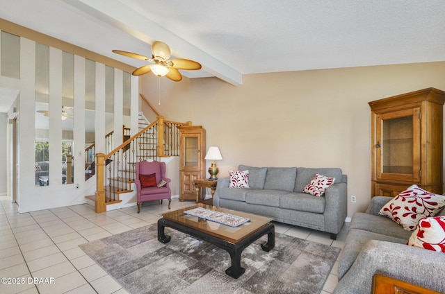 living area with a ceiling fan, light tile patterned floors, vaulted ceiling with beams, and stairs