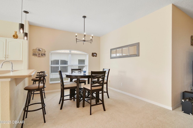 carpeted dining room with an inviting chandelier and sink