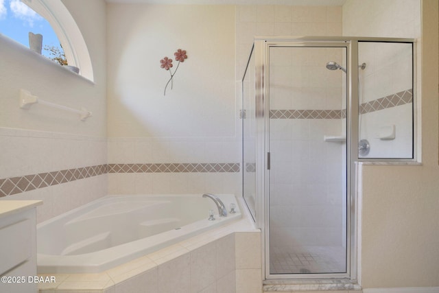 bathroom featuring vanity and independent shower and bath