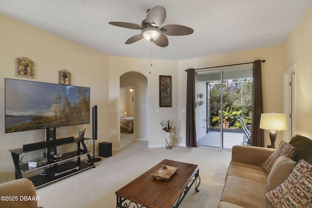 living room featuring ceiling fan, light carpet, and a textured ceiling