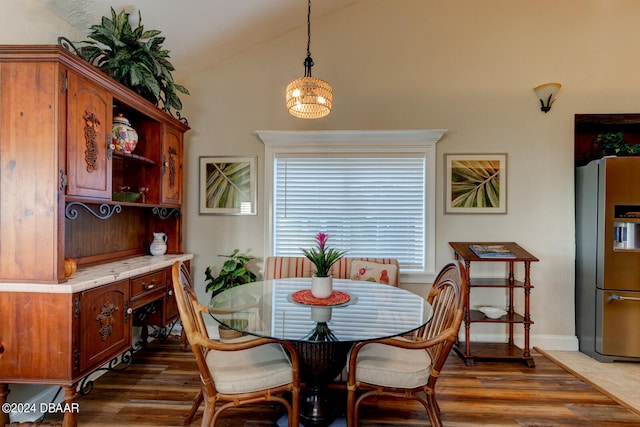 dining space with dark wood-type flooring and vaulted ceiling