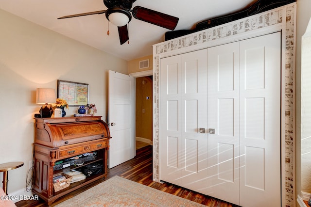 bedroom with dark hardwood / wood-style flooring, a closet, and ceiling fan