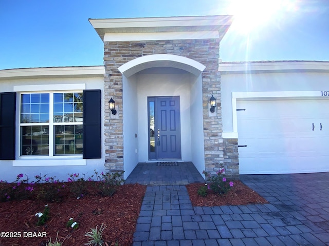 property entrance with an attached garage and stucco siding