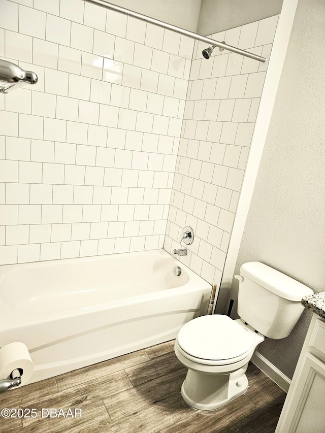 full bath featuring toilet, tub / shower combination, vanity, wood finished floors, and baseboards