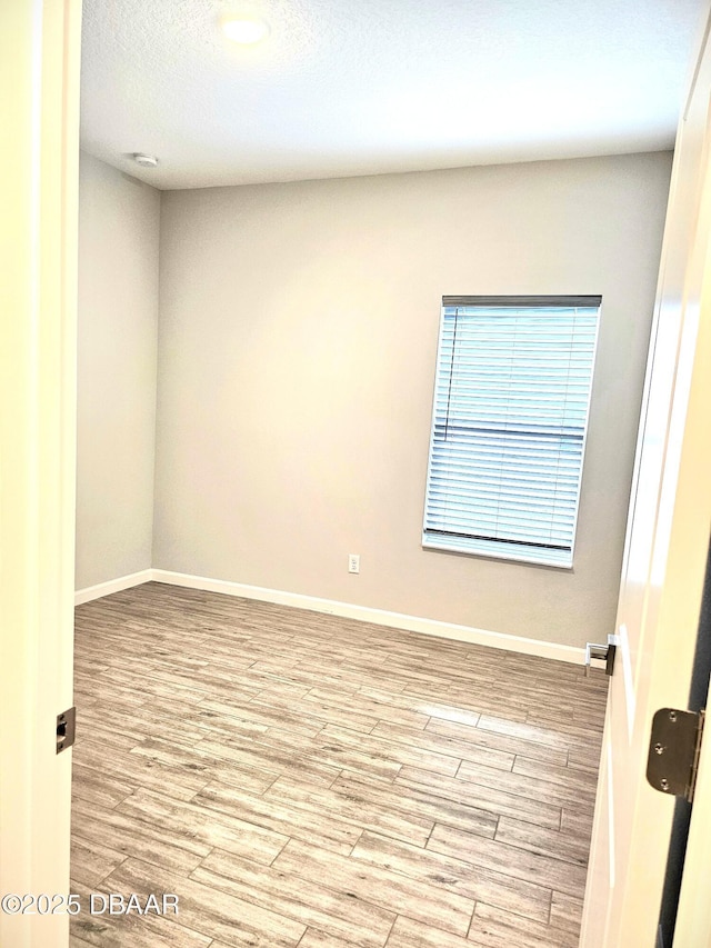 unfurnished room featuring wood finished floors and baseboards