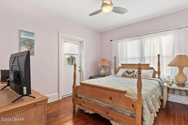 bedroom with multiple windows, dark hardwood / wood-style floors, and ceiling fan