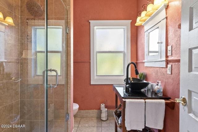 bathroom with tile patterned flooring, vanity, toilet, and a shower with shower door