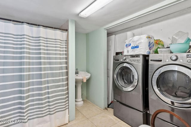 clothes washing area with separate washer and dryer and light tile patterned floors