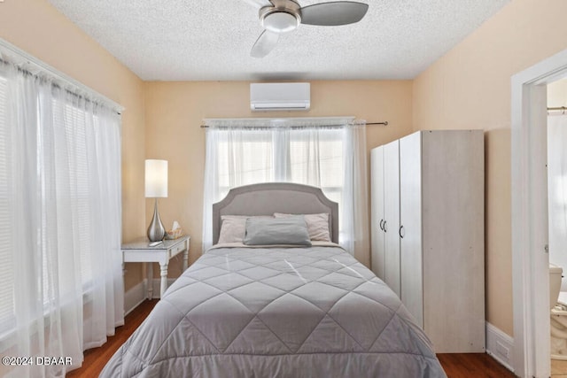 bedroom featuring ceiling fan, a wall mounted AC, a textured ceiling, and wood-type flooring