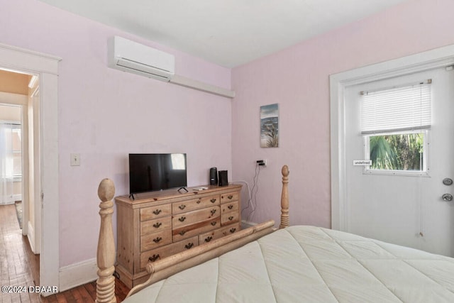 bedroom featuring hardwood / wood-style floors and a wall mounted AC