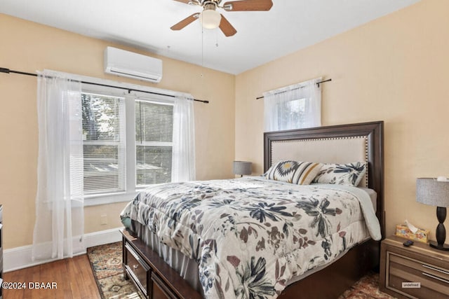 bedroom with wood-type flooring, ceiling fan, and a wall mounted air conditioner