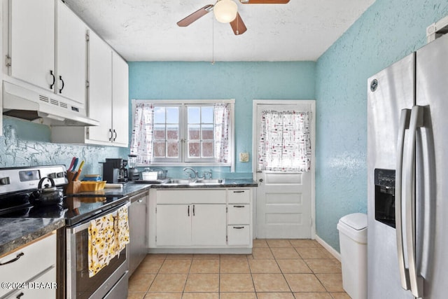 kitchen with white cabinetry, appliances with stainless steel finishes, light tile patterned floors, sink, and ceiling fan