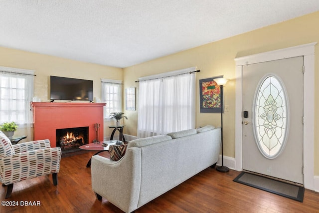 living room featuring hardwood / wood-style floors, a wealth of natural light, and a textured ceiling