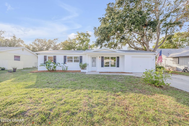 ranch-style home featuring a garage and a front lawn