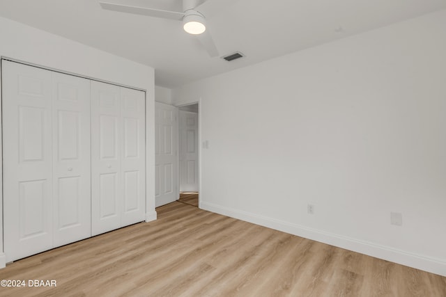 unfurnished bedroom featuring light hardwood / wood-style flooring, ceiling fan, and a closet