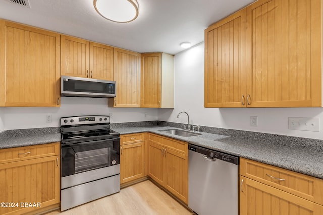 kitchen featuring appliances with stainless steel finishes, light hardwood / wood-style floors, and sink