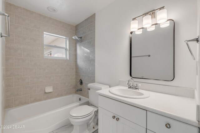 full bathroom with tiled shower / bath, toilet, and vanity