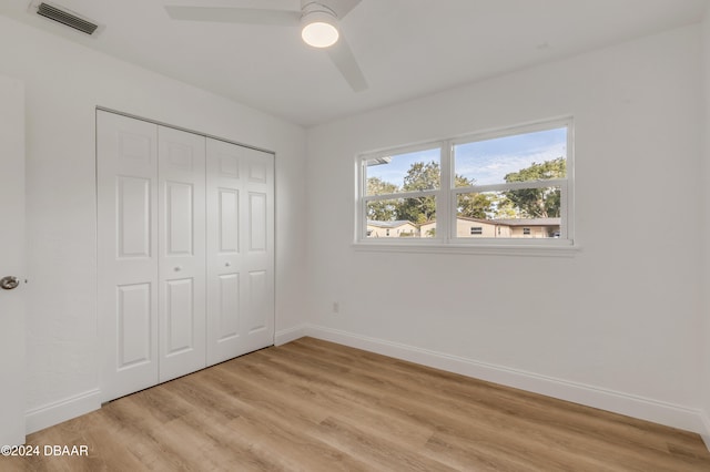 unfurnished bedroom with a closet, light wood-type flooring, and ceiling fan