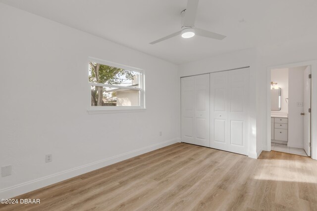 unfurnished bedroom with ceiling fan, ensuite bath, a closet, and light wood-type flooring