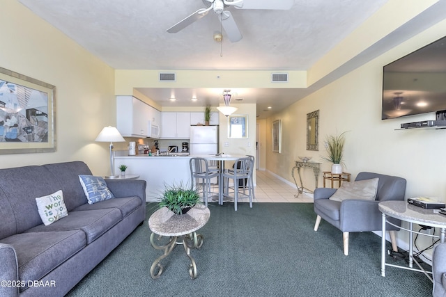 living area with light tile patterned flooring, a ceiling fan, visible vents, and light carpet