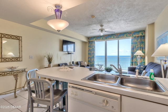 kitchen featuring a sink, a textured ceiling, dishwasher, and open floor plan