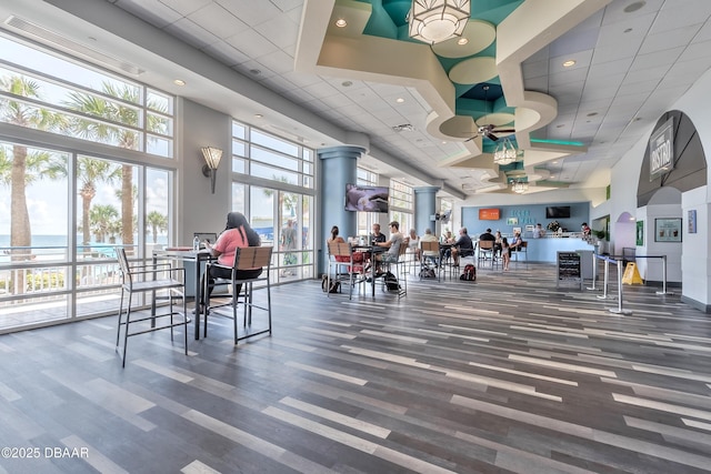 workout area featuring a paneled ceiling, a towering ceiling, and wood finished floors