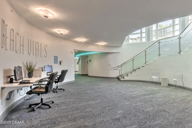 carpeted office space with baseboards and a textured ceiling