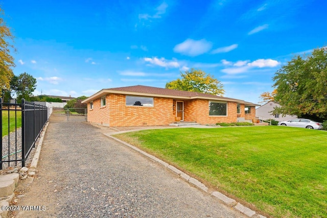 single story home with a front yard, brick siding, and fence