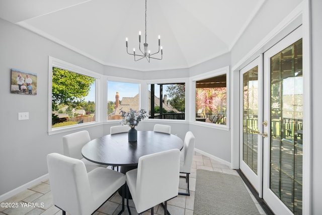 dining room with an inviting chandelier, baseboards, lofted ceiling, and a healthy amount of sunlight