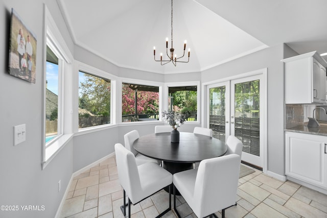 dining area with baseboards, a notable chandelier, a healthy amount of sunlight, and stone tile floors