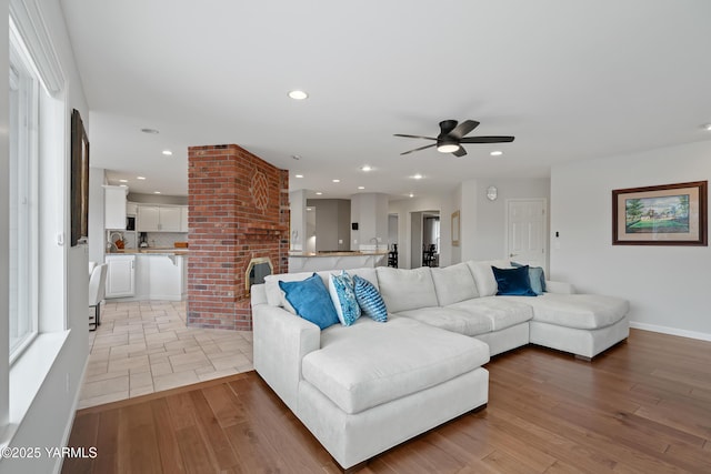 living area featuring baseboards, recessed lighting, ceiling fan, and light wood-style flooring