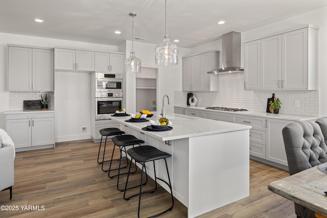 201 E Chinook Rd Lot # 10, Ellensburg, WA 98926 - kitchen with wall chimney range hood, stainless steel appliances, a sink, a breakfast bar, and backsplash