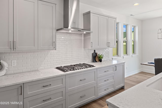 201 E Chinook Rd Lot # 10, Ellensburg, WA 98926 - kitchen featuring wall chimney range hood, stainless steel gas stovetop, backsplash, baseboards, and light wood-style flooring